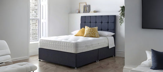 Luxury grey divan bed with upholstered headboard and built-in storage drawers in a modern bedroom – perfect for comfort and space-saving.